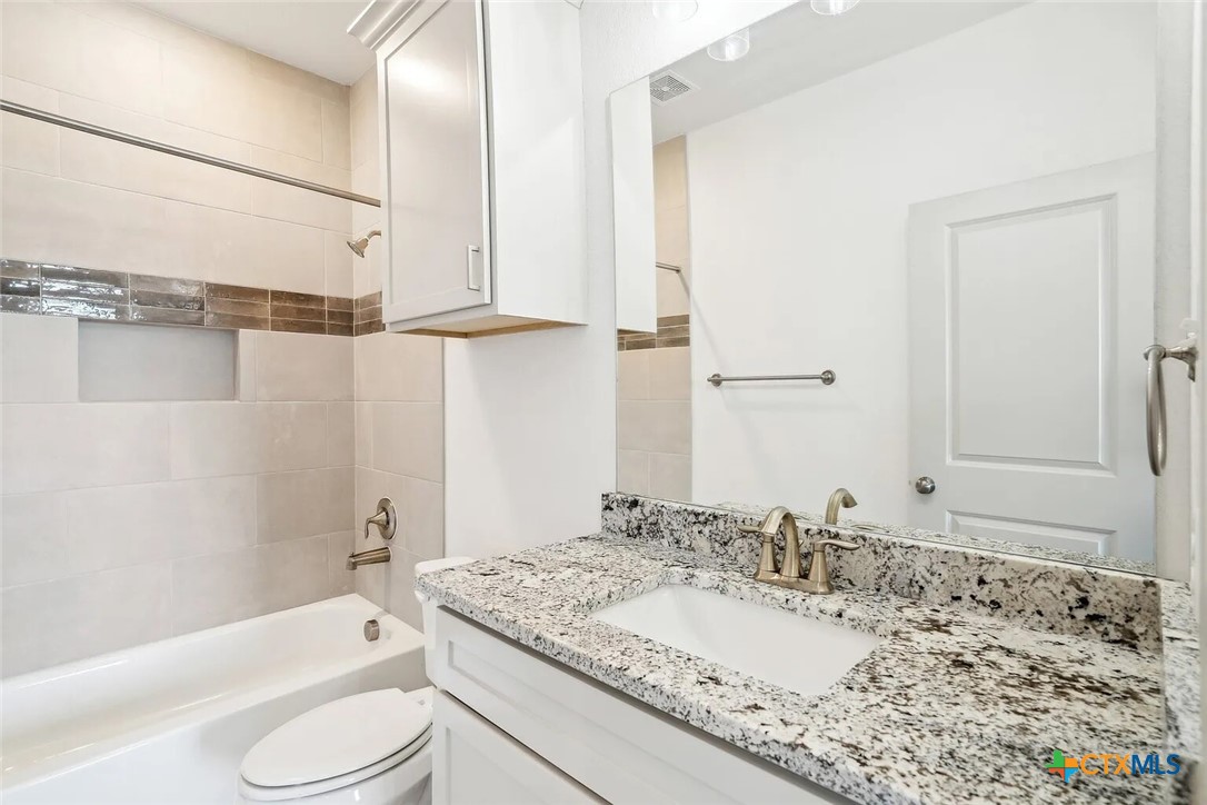 289 Star Grass, Unit 3 Spring Branch, TX 78070 - Photo 23 of 40 a bathroom with a granite countertop sink toilet and shower