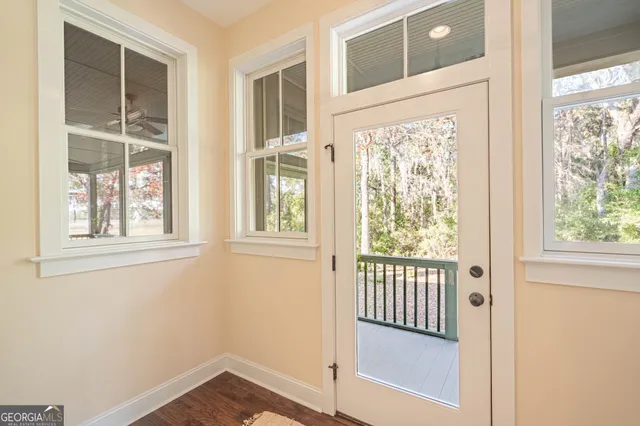 an entryway view with wooden floor and windows
