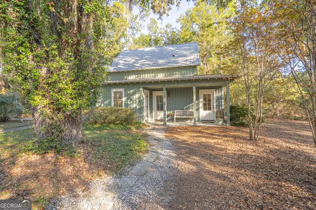 a view of a house with backyard and trees