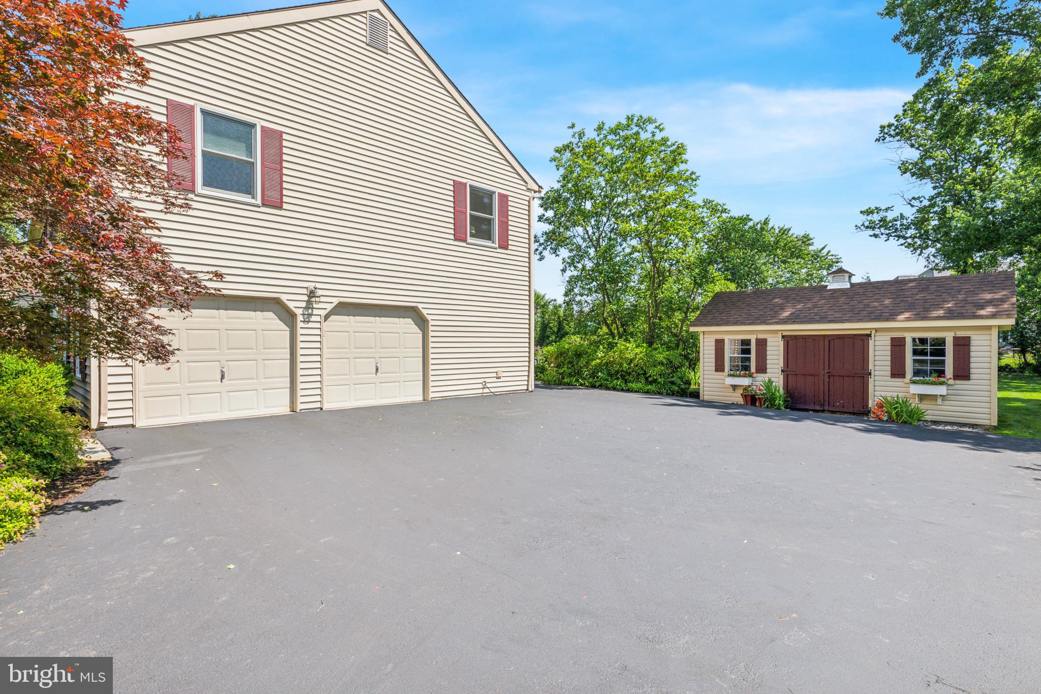 Large driveway, attached 2-car garage, and shed.