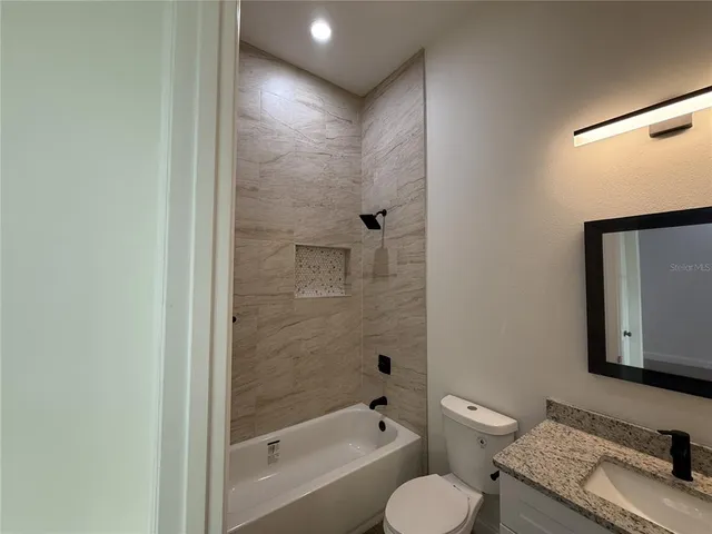 a bathroom with a granite countertop toilet sink and shower