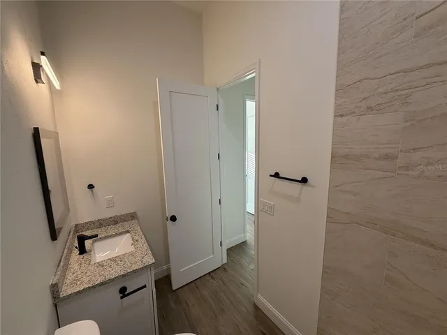 a bathroom with a granite countertop sink toilet and shower