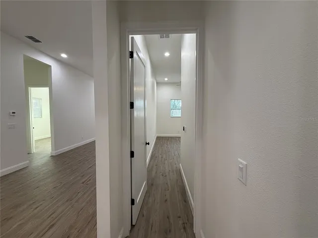 a view of a hallway with wooden floor