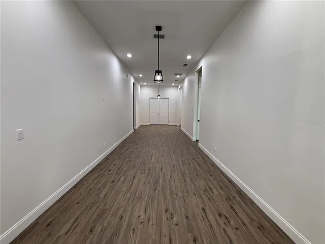 a view of a hallway with wooden floor