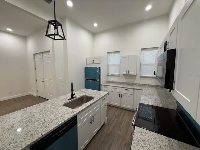 a bathroom with a granite countertop sink a toilet a mirror and shower