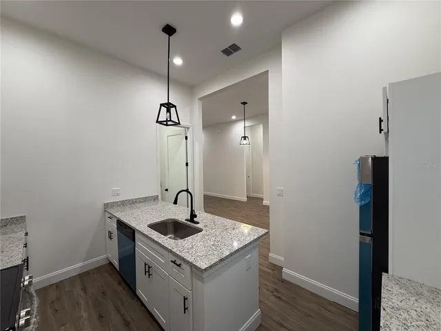 a kitchen with a sink a counter space and a refrigerator