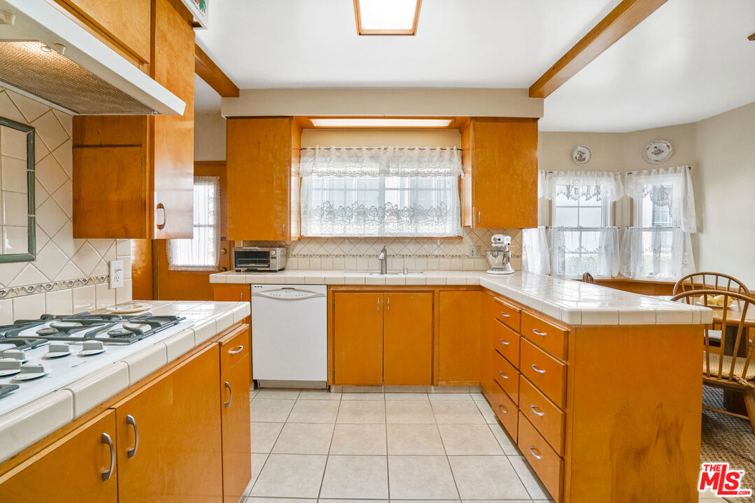 1215 North Everett Street Glendale, CA 91207 - Photo 11 of 31 a kitchen with stainless steel appliances granite countertop a stove a sink and a refrigerator
