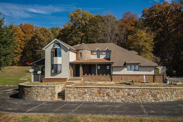 a front view of a house with large trees