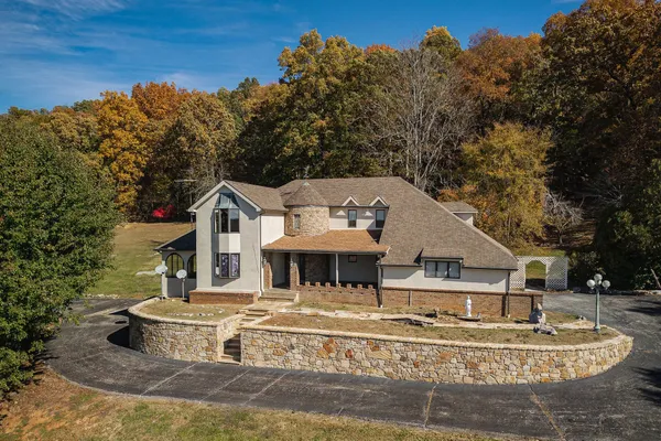 a view of a house with pool and a yard