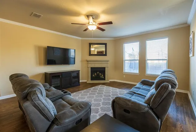 a living room with furniture a flat screen tv and a fireplace