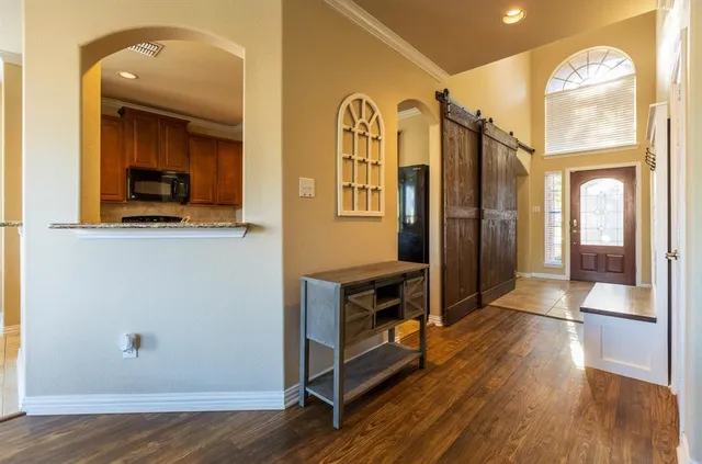 a view of a hallway with wooden floor and a bathroom