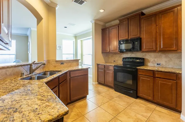 a kitchen with stainless steel appliances granite countertop a stove a sink and a microwave