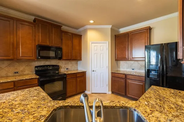 a kitchen with stainless steel appliances granite countertop a refrigerator stove top oven and sink