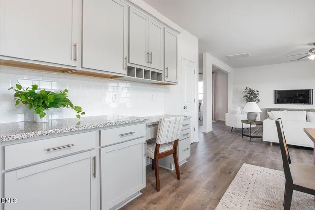 a kitchen with stainless steel appliances white cabinets and wooden floor