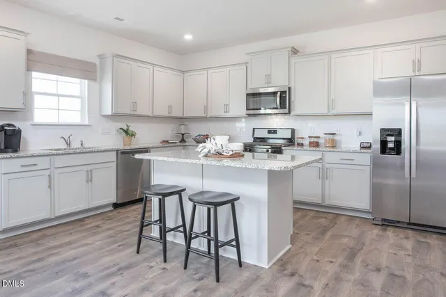 a kitchen with a sink white cabinets and stainless steel appliances