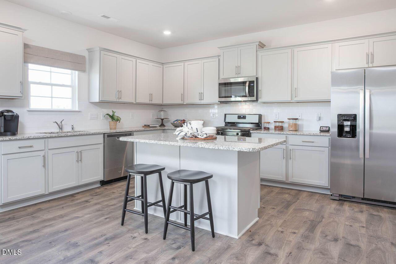 7070 Stockard Road Snow Camp, NC 27349 - Photo 19 of 38 a kitchen with a sink white cabinets and stainless steel appliances
