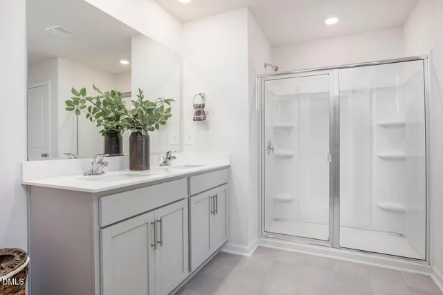 a bathroom with a shower sink and vanity