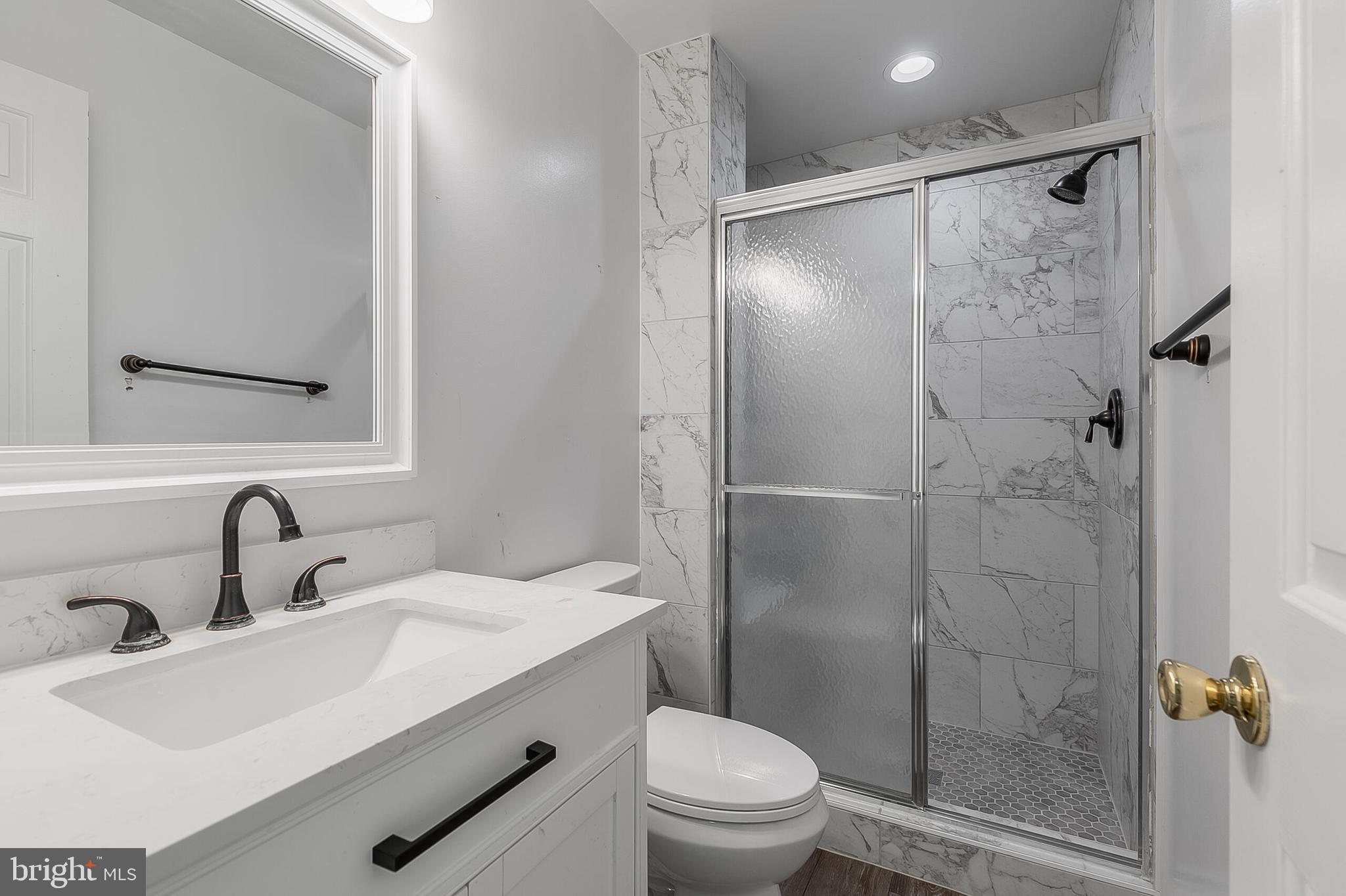 110 Prosperity Avenue Southeast, Unit A Leesburg, VA 20175 - Photo 12 of 22 a bathroom with a shower sink vanity mirror and toilet