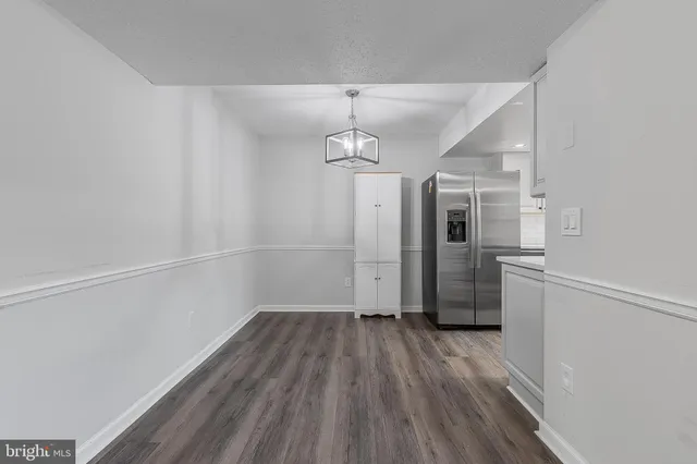 a view of a room with wooden floor electronic appliances and furniture
