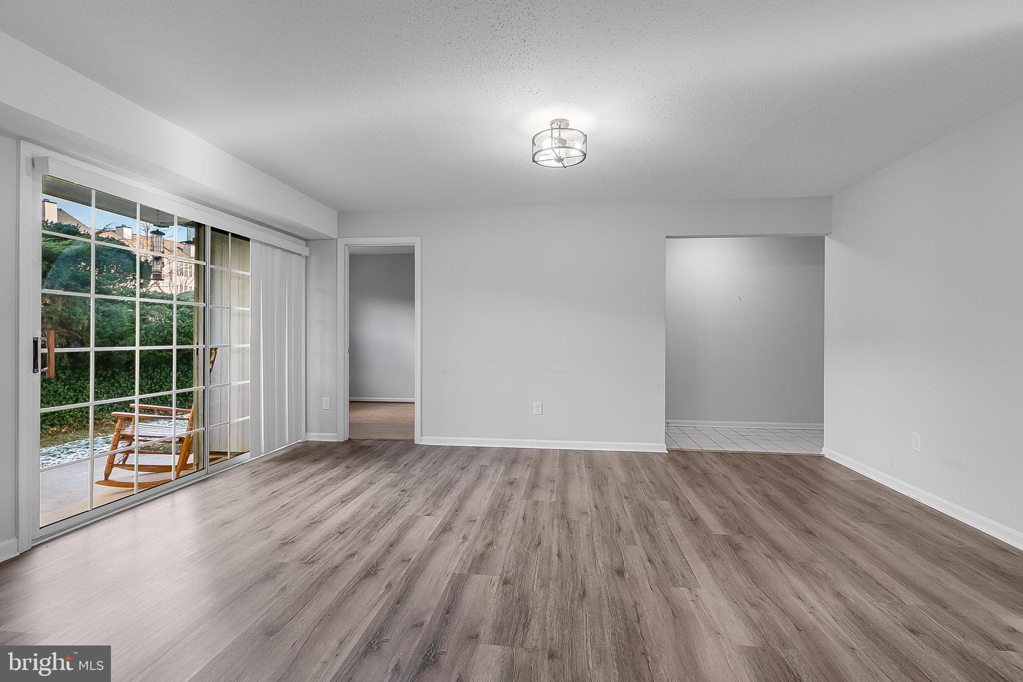 110 Prosperity Avenue Southeast, Unit A Leesburg, VA 20175 - Photo 7 of 22 wooden floor in an empty room with a window