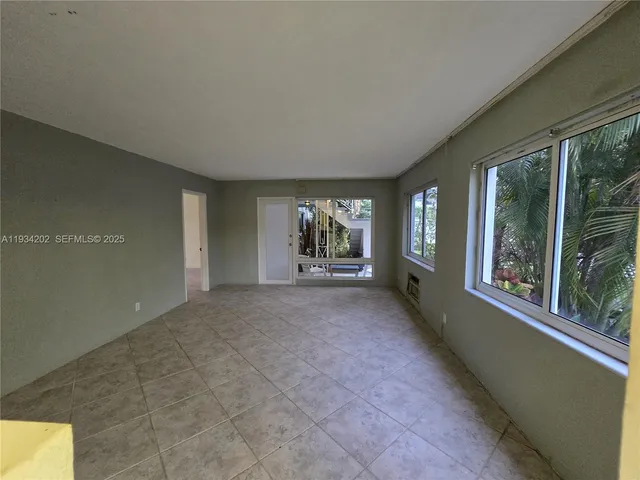 a view of a big room with windows and chandelier fan