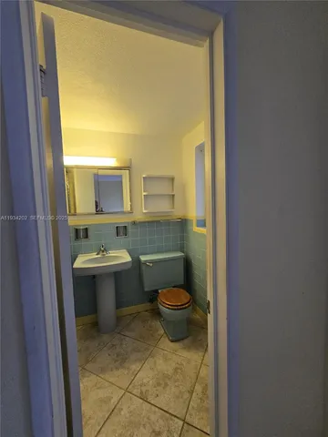 a bathroom with a sink a toilet and mirror