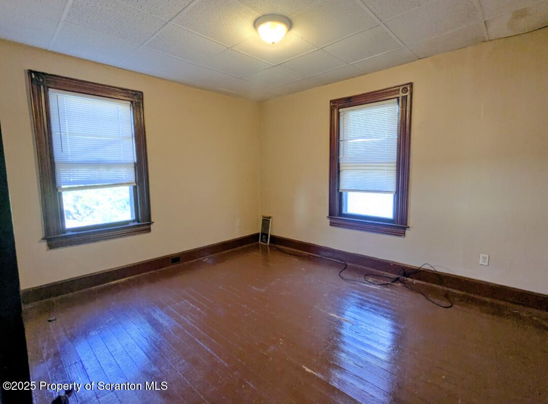 1220 Schlager Street Scranton, PA 18504 - Photo 9 of 10 an empty room with wooden floor and windows