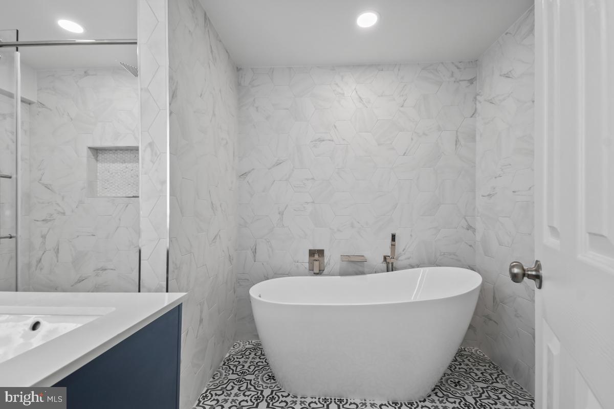 8728 # Courthouse Road Vienna, VA 22182 - Photo 23 of 34 a white bath tub sitting in a bathroom and shower