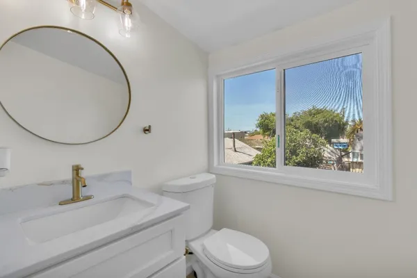 a bathroom with a sink a toilet and a mirror