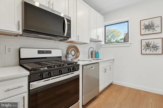 a kitchen with stainless steel appliances a stove a microwave and cabinets