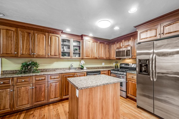 15 Lillian Road Lexington, MA 02420 - Photo 7 of 30 a kitchen with stainless steel appliances granite countertop a refrigerator a sink dishwasher and wooden cabinets with wooden floor