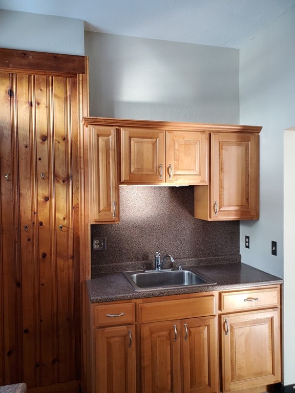 91 Ocean Street, Unit 1 Lynn, MA 01902 - Photo 2 of 9 a kitchen with granite countertop a sink a window and stainless steel appliances