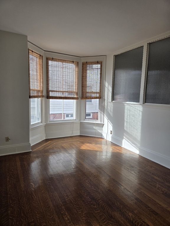 91 Ocean Street, Unit 1 Lynn, MA 01902 - Photo 5 of 9 a view of an empty room with wooden floor and a window