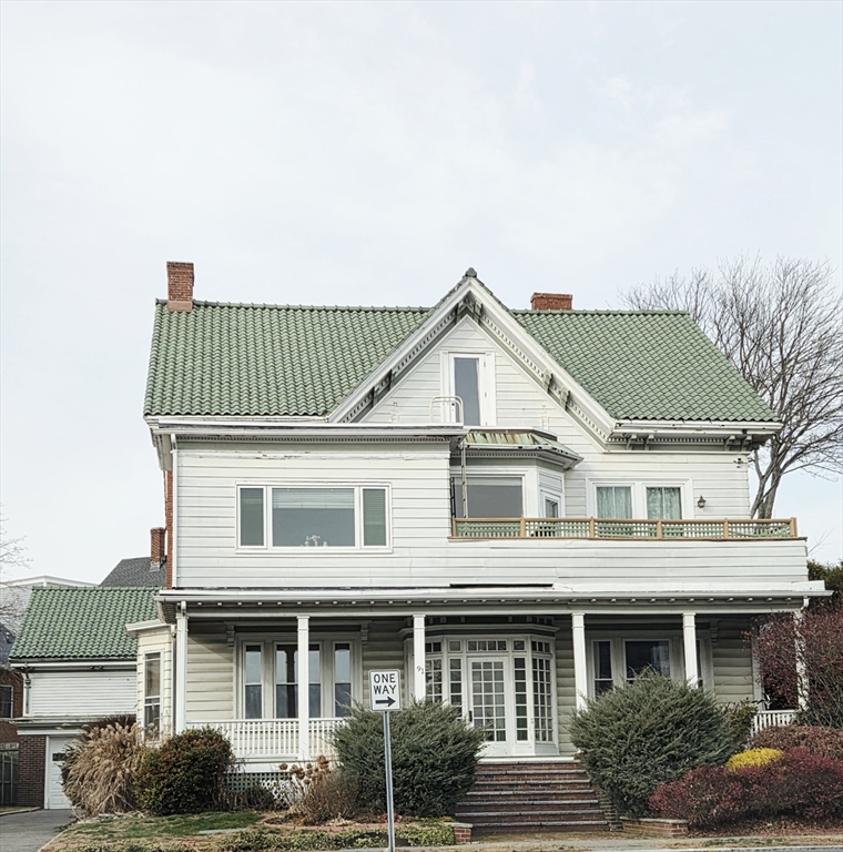 91 Ocean Street, Unit 1 Lynn, MA 01902 - Photo 9 of 9 a view of a white house with large windows and a yard