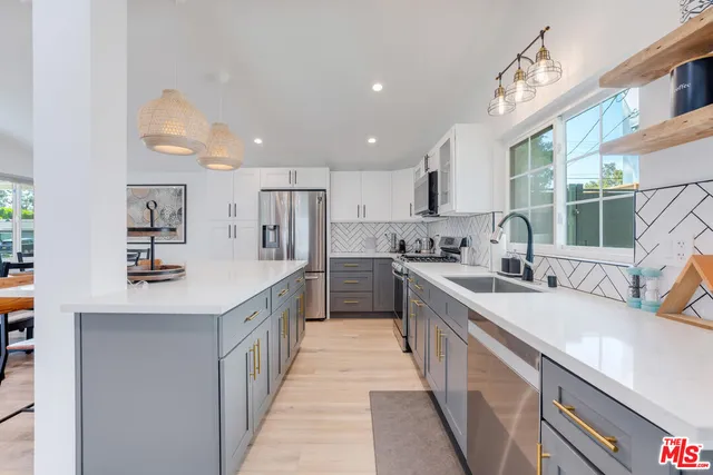 a kitchen with kitchen island a stove a table and chairs in it