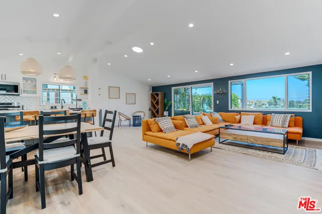 a living room with furniture large window and a wooden floor