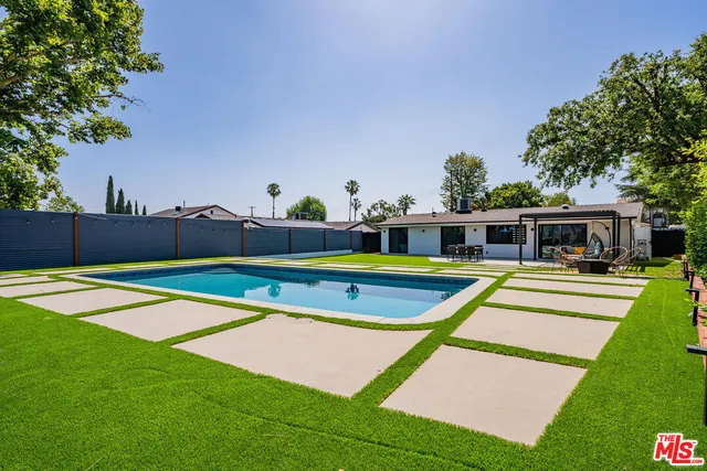 a view of a patio with table and chairs potted plants and a large tree