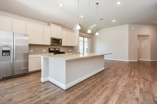 a kitchen with stainless steel appliances a refrigerator sink and microwave