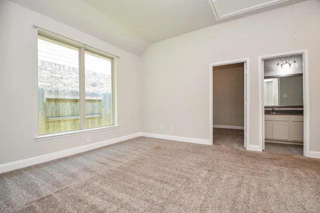 an empty room with windows and refrigerator