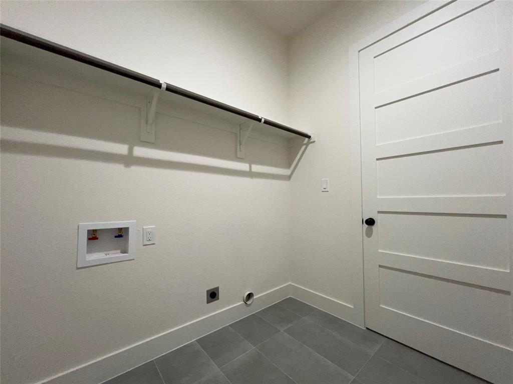121 Cartwright Park Road Weatherford, TX 76087 - Photo 17 of 17 Laundry area featuring a hanging rod, modern panel door with black hardware, and gray tile flooring