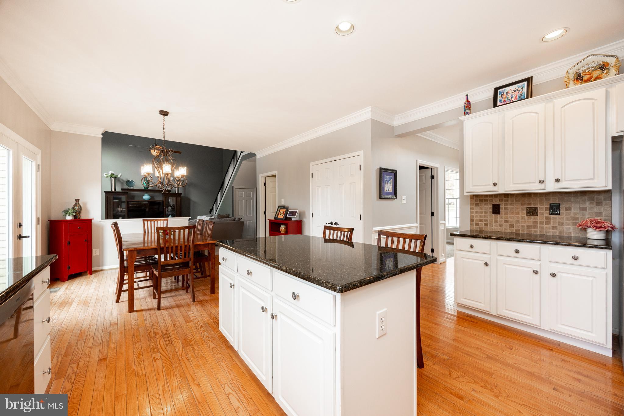 113 Blue Ribbon Way Downingtown, PA 19335 - Photo 12 of 50 a kitchen with stainless steel appliances kitchen island granite countertop a stove a sink a refrigerator and white cabinets with wooden floor