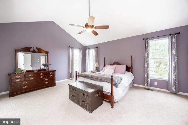 a spacious bedroom with a bed and a chandelier