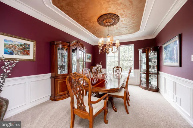 a dining room with furniture a chandelier and window