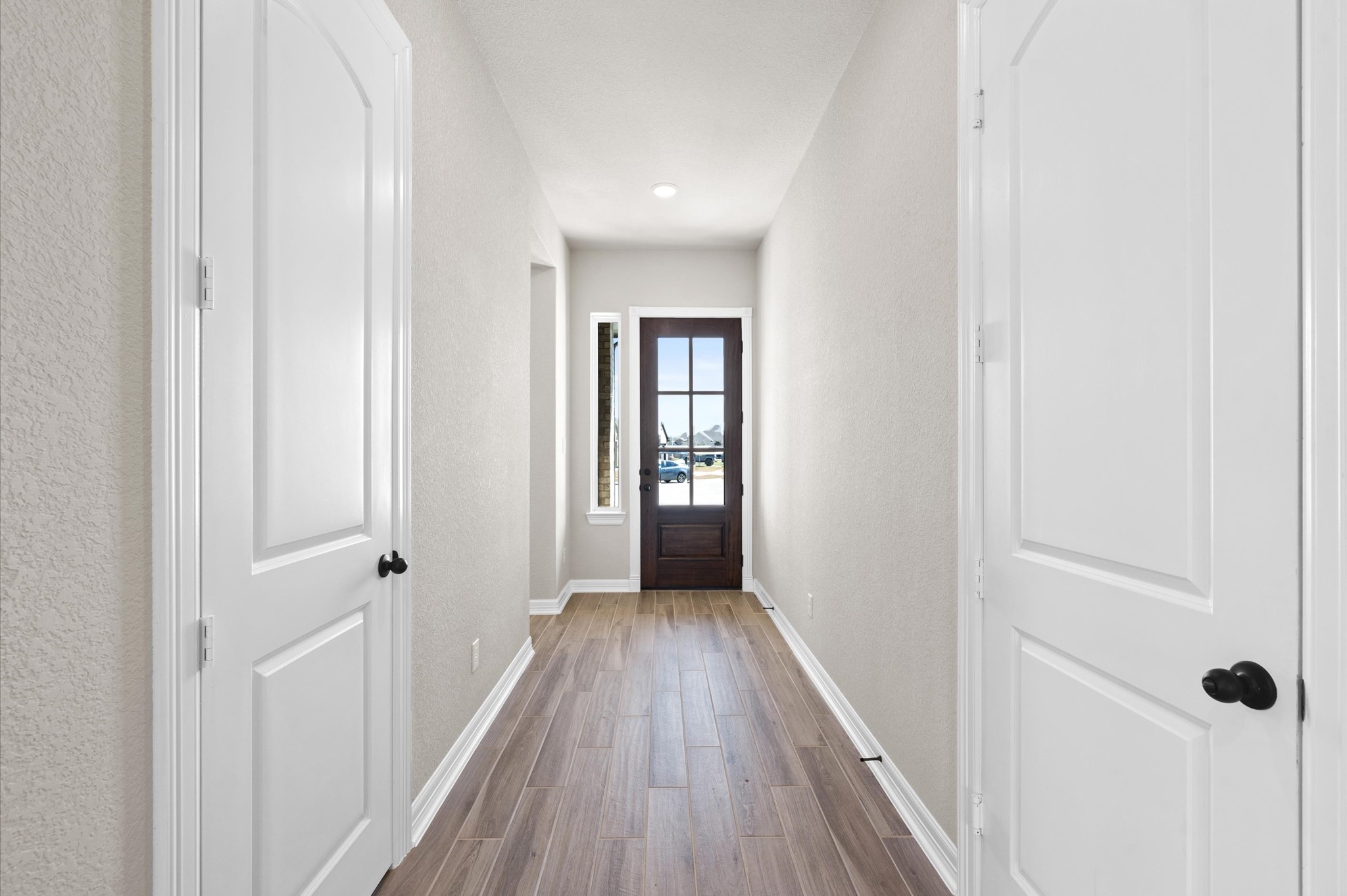 a view of a hallway with wooden floor and closet