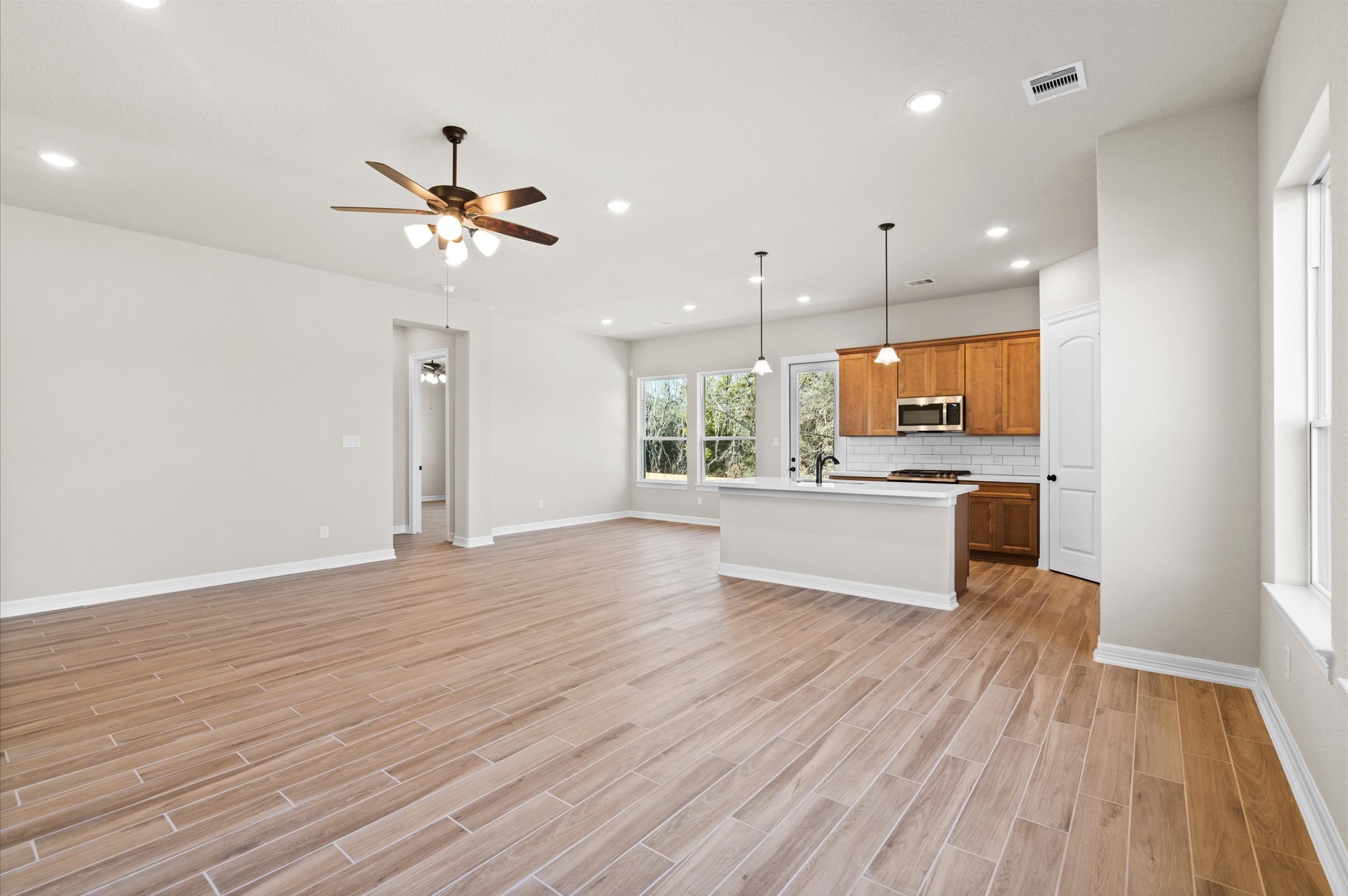 1225 Friendship Trail Seabrook, TX 77586 - Photo 3 of 22 a large kitchen with kitchen island a stove a sink dishwasher a refrigerator and white cabinets with wooden floor