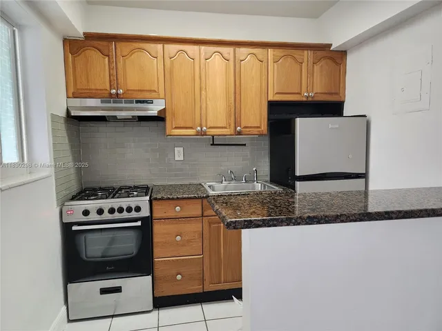a kitchen with granite countertop a stove a sink and a granite counter tops