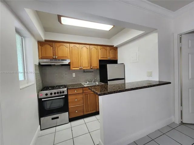 a kitchen with stainless steel appliances granite countertop a stove a sink and a refrigerator