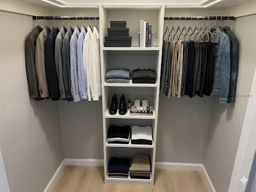 a view of walk in closet with clothes and shoes