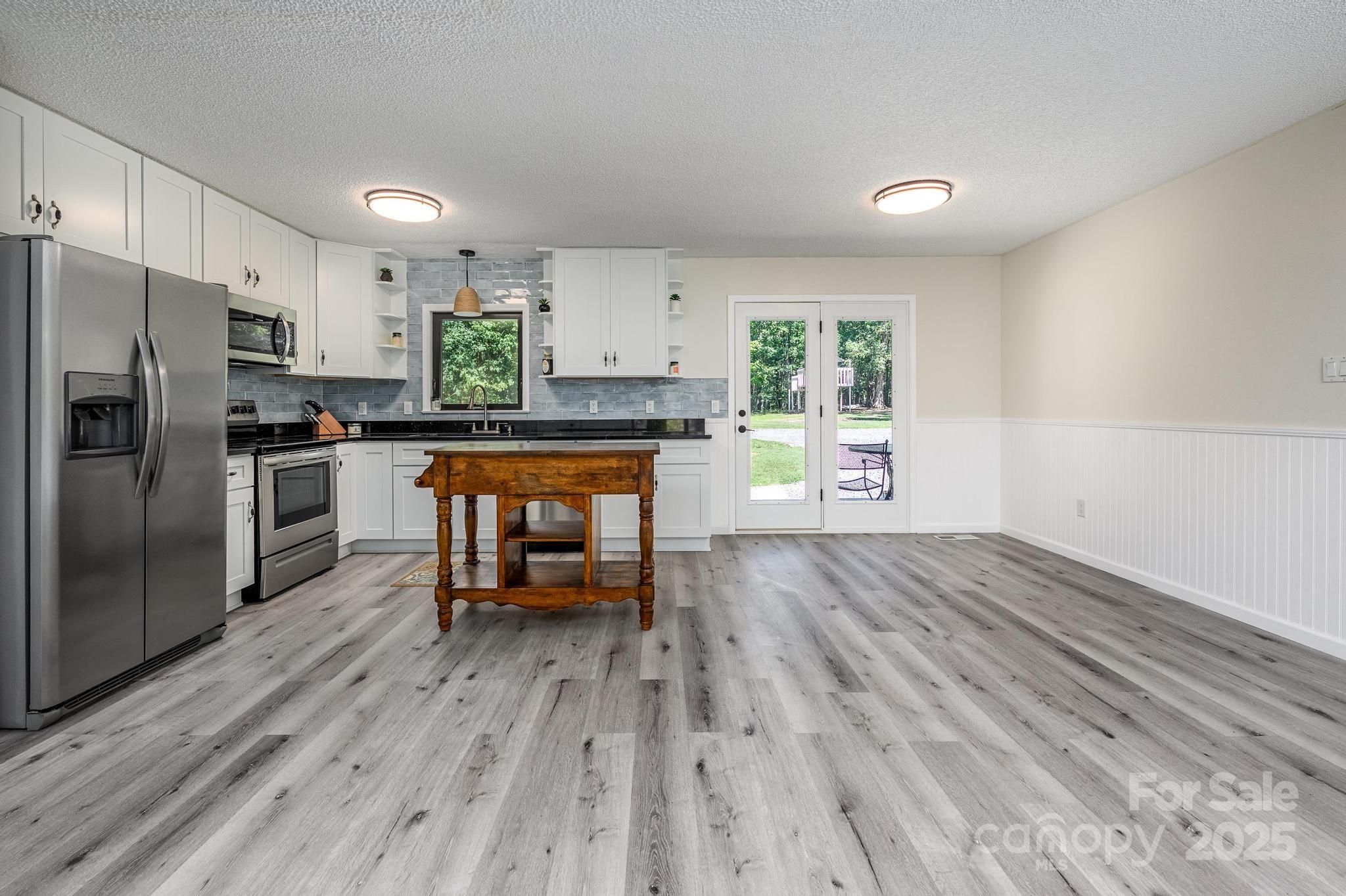 160 Clairmont Road Salisbury, NC 28146 - Photo 12 of 42 a kitchen with stainless steel appliances a stove top oven a refrigerator cabinets and wooden floor