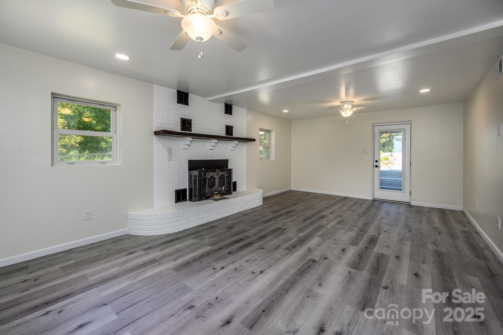 160 Clairmont Road Salisbury, NC 28146 - Photo 26 of 42 an empty room with wooden floor fireplace and windows